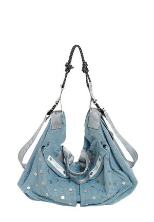 Bolsa tote de tela azul clara con tachuelas circulares plateadas, correas grises ajustables y asas negras trenzadas anudadas en la parte superior.