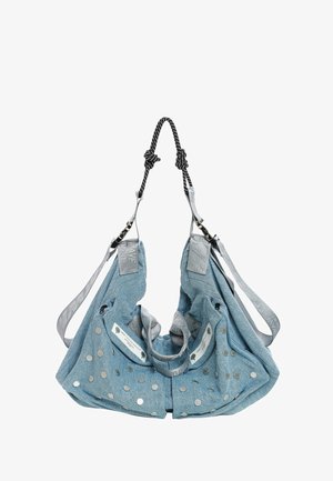 Bolsa tote de tela azul clara con tachuelas circulares plateadas, correas grises ajustables y asas negras trenzadas anudadas en la parte superior.