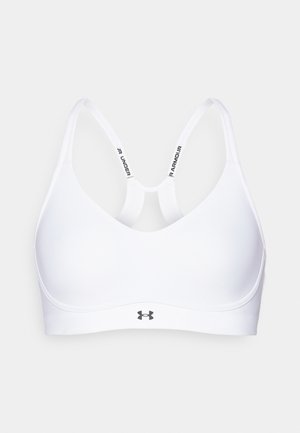 Valkoinen urheiluliivit, jossa on tyylikäs muotoilu, säädettävät hihnat ja logo vyötäröllä. Valmistettu sileästä ja joustavasta kankaasta.