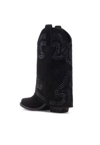Botas de vaquero de ante negro con un diseño curvado, adornadas con detalles de tachuelas y un tacón pequeño. Con un lazo para facilitarlas al ponérselas.