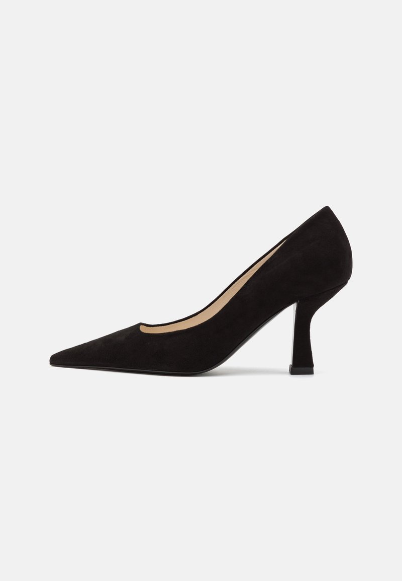 Sort ruskind stiletto-sko med spids tå, lav struktureret hæl og udskåret designside, prydet med en glat beige indersål og en strømlinet silhuet.