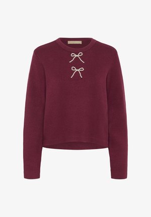 Burgundia värvi pikade varrukatega sviiter, ribatekstuuriga ning ees kahel dekoratiivsel pärlakkentil. Ümmargune kaelus, lühikeseks lõigatud mudel.