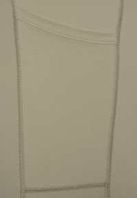 Beige tyg med en slät textur har kontrasterande sömmar och en liten infälld fickdetalj på ena sidan. Enkel och funktionell design.