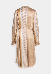 Långärmad klänning i gyllene satin, med vertikala ränder och cirkulära mönster. Elastisk midja, krage och knappade ärmslut.