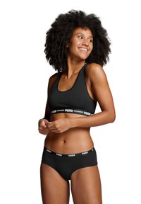 Schwarzer Sport-BH und passende Unterwäsche mit glatter Textur. Beide haben ein breites weißes Logo-Band. Einfaches, minimalistisches Design.