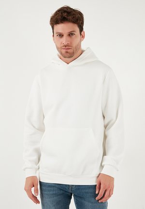 Valkoinen huppari kengurutaskulla, kiristysnauhalla varustettu huppu, resorit hihansuissa ja rento istuvuus. Valmistettu pehmeästä, teksturoidusta kankaasta.