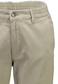 Pantaloni beige in misto cotone con vita elastica e chiusura con bottone, tasche frontali e dettagli di cuciture visibili.