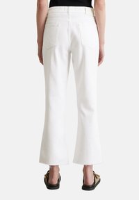 Witte flare jeans met een gemiddelde taille, twee achterzakken en rafelige zomen, voorzien van een gladde katoenen textuur en een strakke uitstraling.