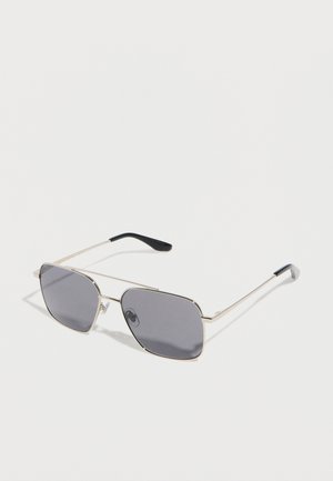 Metal-framed sunglasses with thin gold arms and dark rectangular lenses on a plain white background.