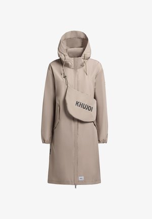 Bež veekindel jakk kapuutsiga, elastsete mansettide, küljetaskute ja eemaldatava kottiga, millel on hall tekst "KHUJO 2001".