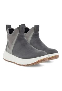 Botines de ante gris con una media suela blanca y suela texturizada de varios colores. Cuentan con paneles laterales elásticos y pestañas de agarre para ponerlos y quitarlos fácilmente.