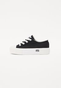 Fekete vászon sneaker fehér gumitalppal, kerek orral és fehér fűzőkkel. Oldalán egy kis logóval és texturált talppal rendelkezik.