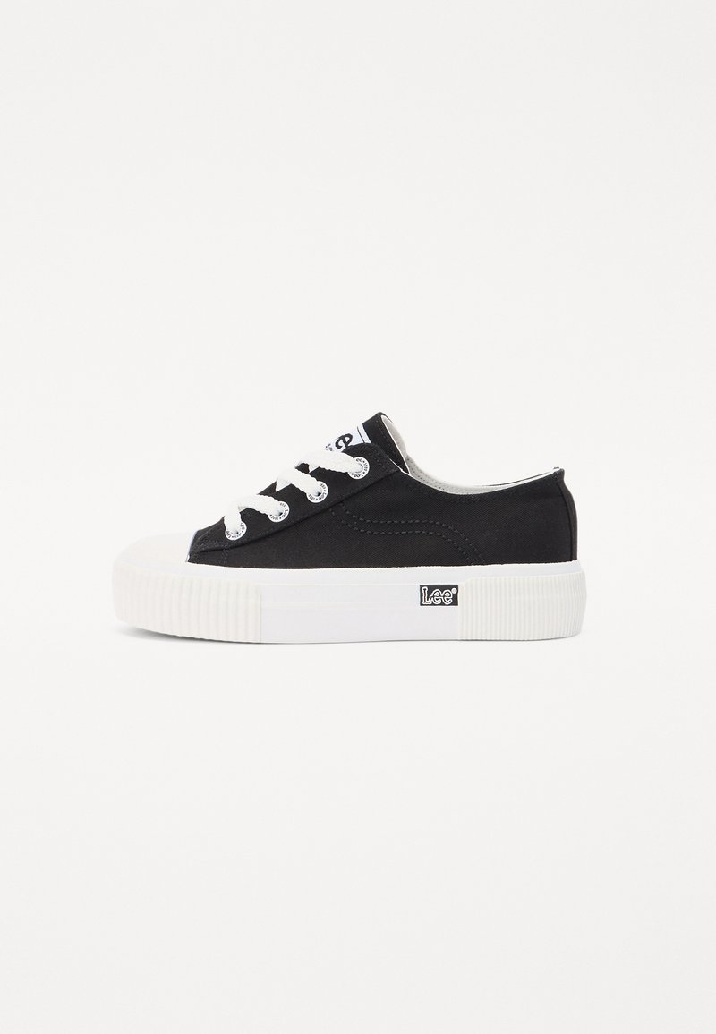 Fekete vászon sneaker fehér gumitalppal, kerek orral és fehér fűzőkkel. Oldalán egy kis logóval és texturált talppal rendelkezik.
