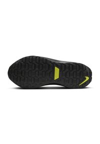 Czarna podeszwa sportowego buta z teksturowanym wzorem bieżnika; charakteryzuje się wyraźnym zielonym logo Nike i etykietą na śródpodeszwie.