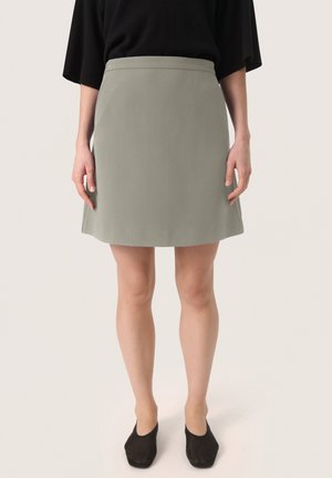 Light grey, tailored A-line skirt with a smooth texture. Features a flat waistband and falls above the knee, paired with black flats.