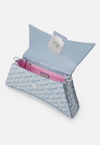 Sininen vegaaninen nahkalaukku, jossa on toistuva "Barbie"-kuvio, tilava vaaleanpunainen sisäosa ja napsautuskiinnitys metallisella yksityiskohdalla.