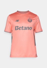 Jersey corto de manga corta en rosa claro con patrón geométrico texturizado, acentos grises y logos en el pecho y los hombros. Diseño de cuello redondo.