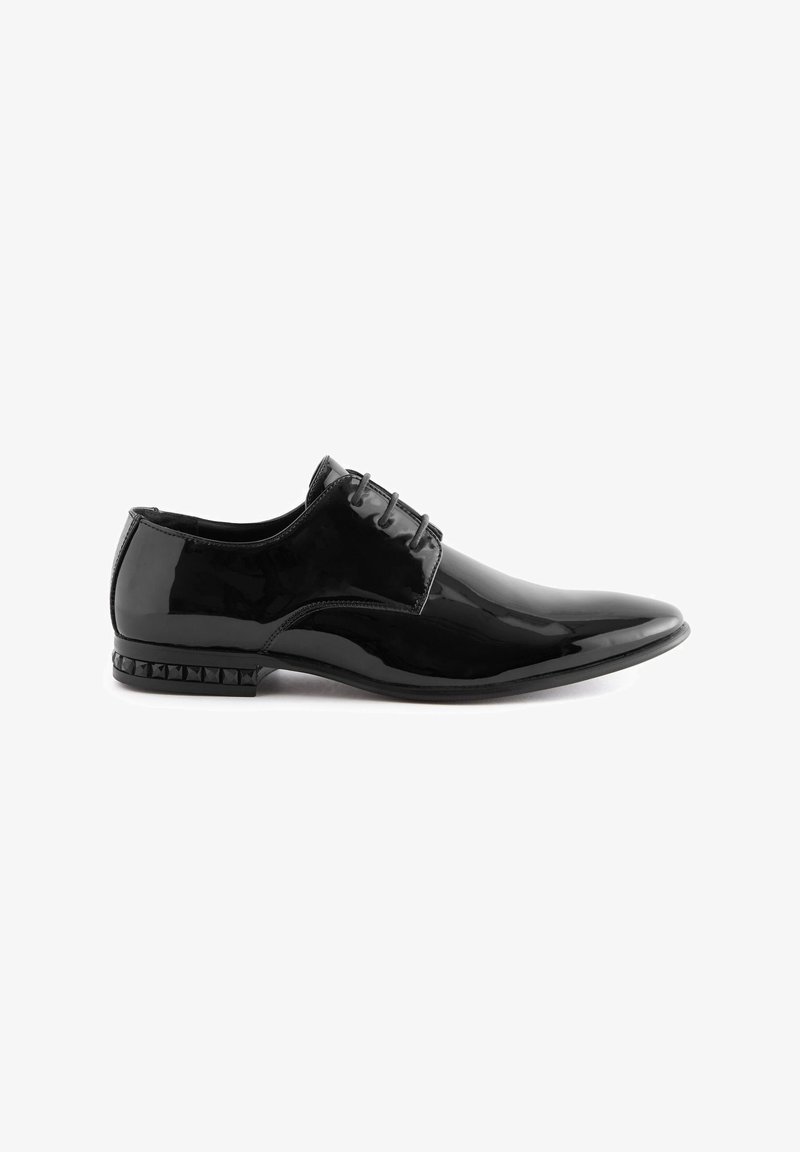 Schwarze Lacklederschuhe mit spitzem Zehenbereich, Vier-Ösen-Schnürung und genageltem Absatz. Glatte Textur und glänzende Oberfläche.