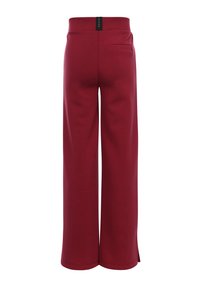 Grote broek gemaakt van bordeauxrode stof, met een hoge tailleband, een achterzak en zijsplitten aan de onderkant. Over het algemeen een gladde textuur.