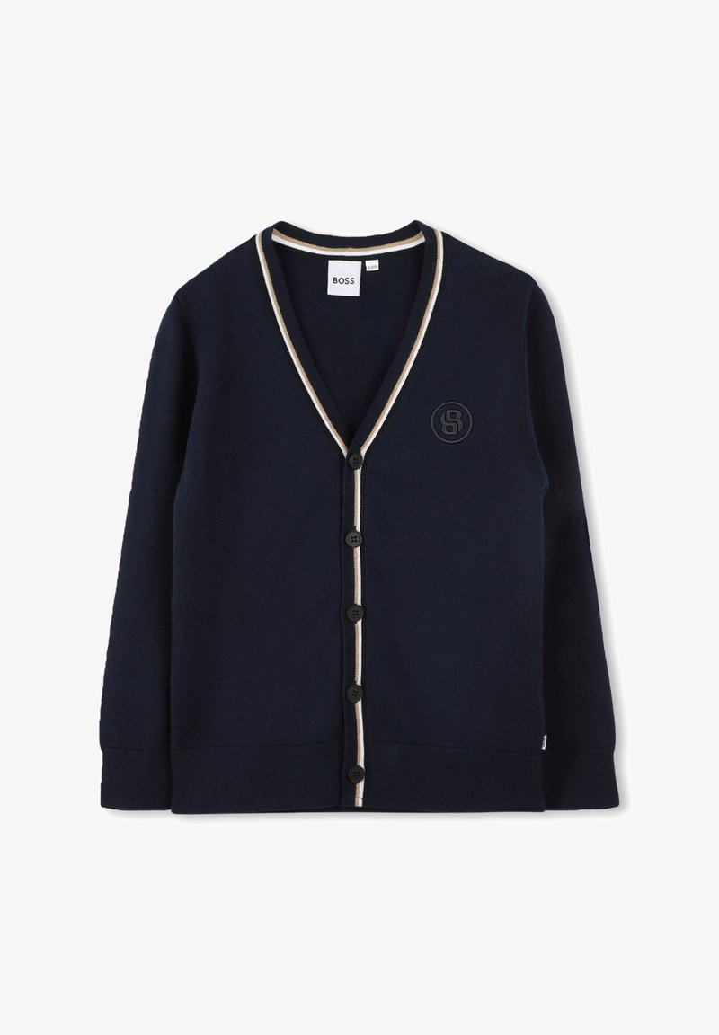 Cardigan bleu marine en tissu texturé, avec un col en V, des finitions crème contrastantes, des boutons noirs et un logo brodé sur la poitrine.