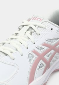 Scarpa da corsa bianca con accenti rosa, pannelli in mesh testurizzati e lacci piatti; presenta un design perforato e un colletto imbottito per il comfort.