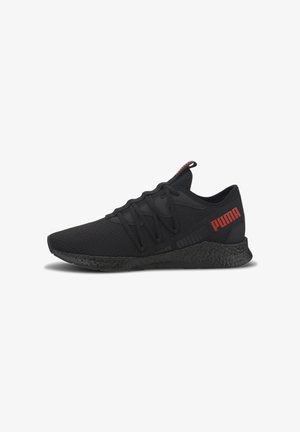 Chaussure de sport noire avec un dessus en mesh, un système de laçage, une semelle noire texturée et un accent rouge du logo "Puma" sur le côté.