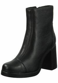 Botín negro de tobillo fabricado en cuero suave, con punta redondeada, detalles de costura vertical y un tacón cuadrado grueso.