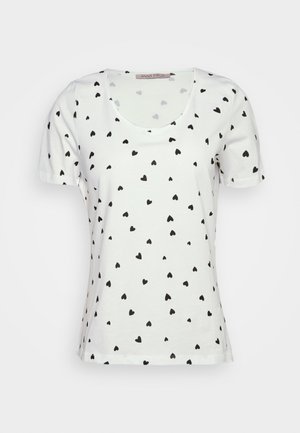 T-shirt blanc à manches courtes avec un col rond et un motif de petits cœurs noirs sur l'ensemble. Fabriqué en tissu coton doux.
