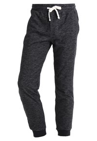 Black sweatpants made of textured fabric, featuring a drawstring waist, elastic cuffs, and side pockets for utility.