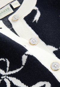 Cardigan lavorato a maglia blu navy e bianco con motivo floreale, bottoni in madreperla e etichetta Ted Baker all'interno del colletto.