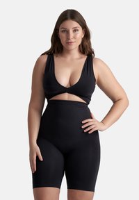 Bodysuit negro con escote profundo en V, tirantes anchos, corte en la zona media y cobertura alta en los muslos, fabricado con una tela suave y elástica.