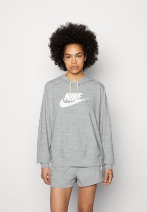 Felpa grigia Nike con un grande logo bianco e cordino regolabile, abbinata a pantaloni corti grigi coordinati con un piccolo logo sulla gamba.