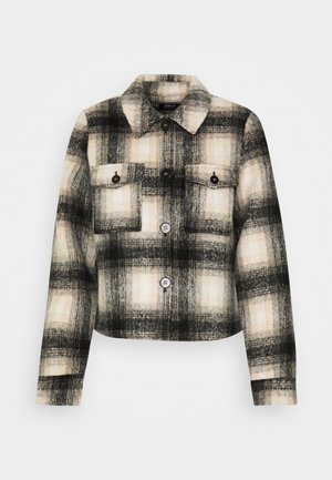 Karierter Flanelljacke in Schwarz, Weiß und Beige. Sie verfügt über zwei Brusttaschen, schwarze Knöpfe und einen klassischen Kragen. Verkürzter Schnitt.