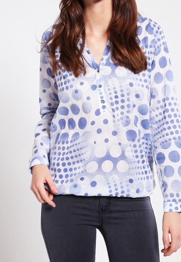 Chemise à manches longues bleu clair avec des motifs circulaires blancs et bleu foncé de différentes tailles, dotée d'une encolure boutonnée et d'une texture douce.