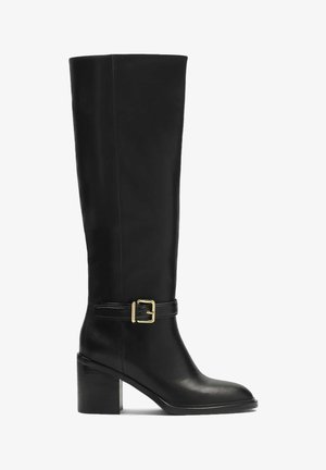 Melni zeķuboti līdz ceļiem, kas izgatavotas no gludas ādas, ar blokveida papēdi, zelta sprādzi un elegantu siluetu.