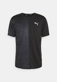 Camiseta deportiva negra con un patrón de cebra texturizado en un lado, tejido liso en el otro, y un logo de Puma blanco en el pecho.