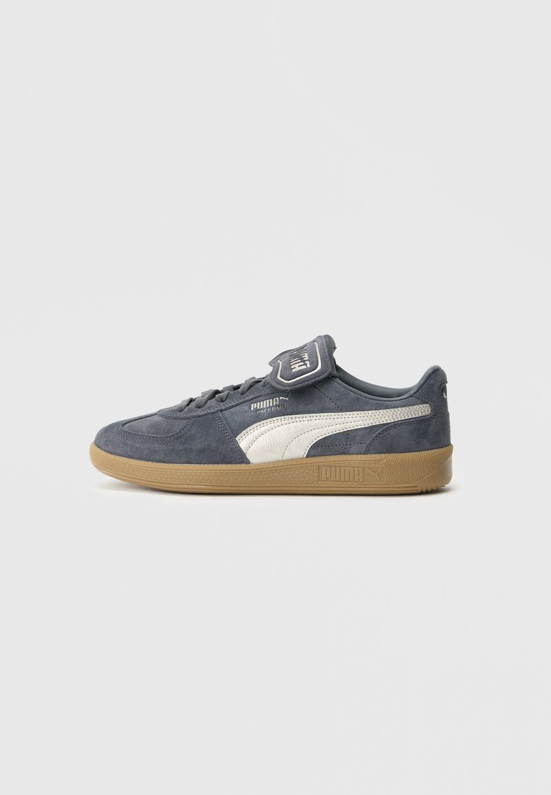 Zamszowe trampki w ciemnoszarym kolorze z białymi akcentami. Posiadają zaokrąglony nosek, sznurowanie, wyściełany kołnierz oraz gumową podeszwę.