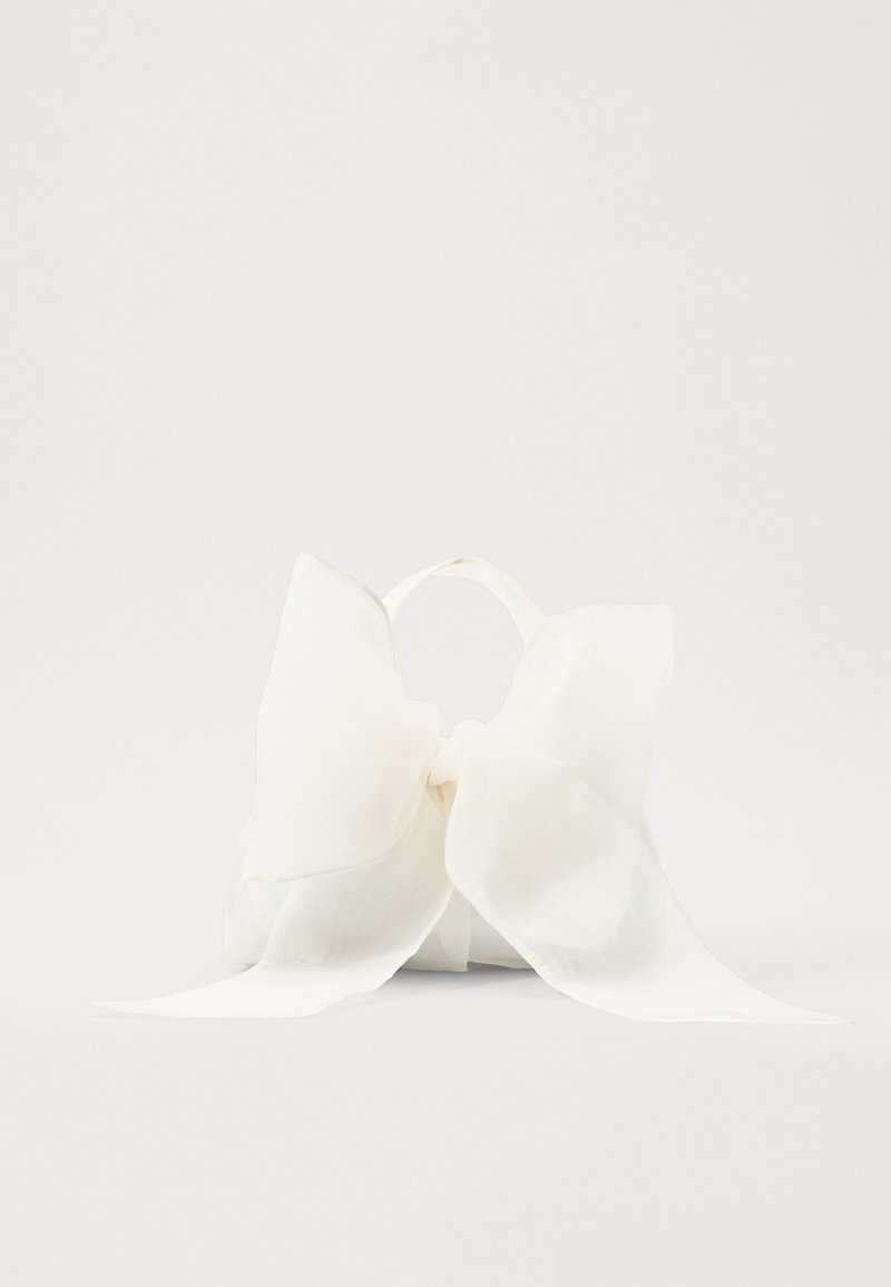 Bijela satenska torbica s velikim uzorkom mašne sprijeda, glatke teksture i dugim trakama koje vise.