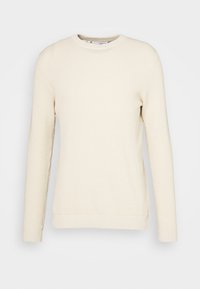 Krämfärgad tröja med rund hals, långa ärmar och texturerat stickat mönster; har ribbade mudd och fåll.