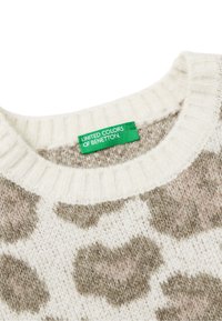 Maglione con collo a girocollo a coste, caratterizzato da una base crema e una stampa animale pelosa in marrone e beige chiaro. Etichetta del marchio verde visibile.