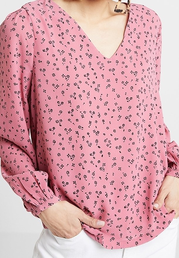 Roze blouse met kleine zwarte bloemenpatronen, V-hals, lange pofmouwen met elastische manchetten en een relaxte pasvorm.