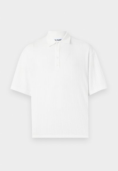Polo shirt blanc à manches courtes avec un col, présentant une texture côtelée et une patte de boutonnage à quatre boutons. Design épuré et simple.