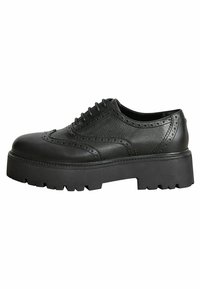 Chaussures à lacets en cuir noir présentant un design brogue avec une semelle épaisse et robuste ainsi qu'une finition texturée. Découpes décoratives le long de la tige.
