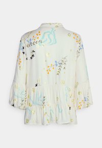 Blusa leggera in crema con motivi floreali in blu, arancione e verde, dotata di un orlo arricciato e maniche a tre quarti.