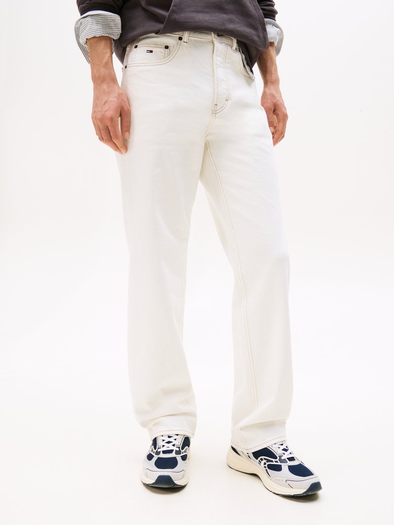 Hvite denimjeans med kontrastsøm, rett passform og fem-lommers design. Kombinert med marineblå og hvite treningssko.