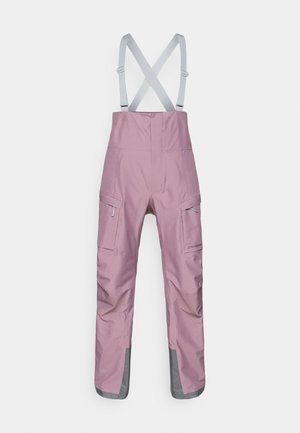 Różowe wodoodporne spodnie na szelkach z regulowanymi szarymi szelkami, kieszeniami typu cargo oraz szarymi akcentami przy mankietach. Gładka, trwała tkanina.