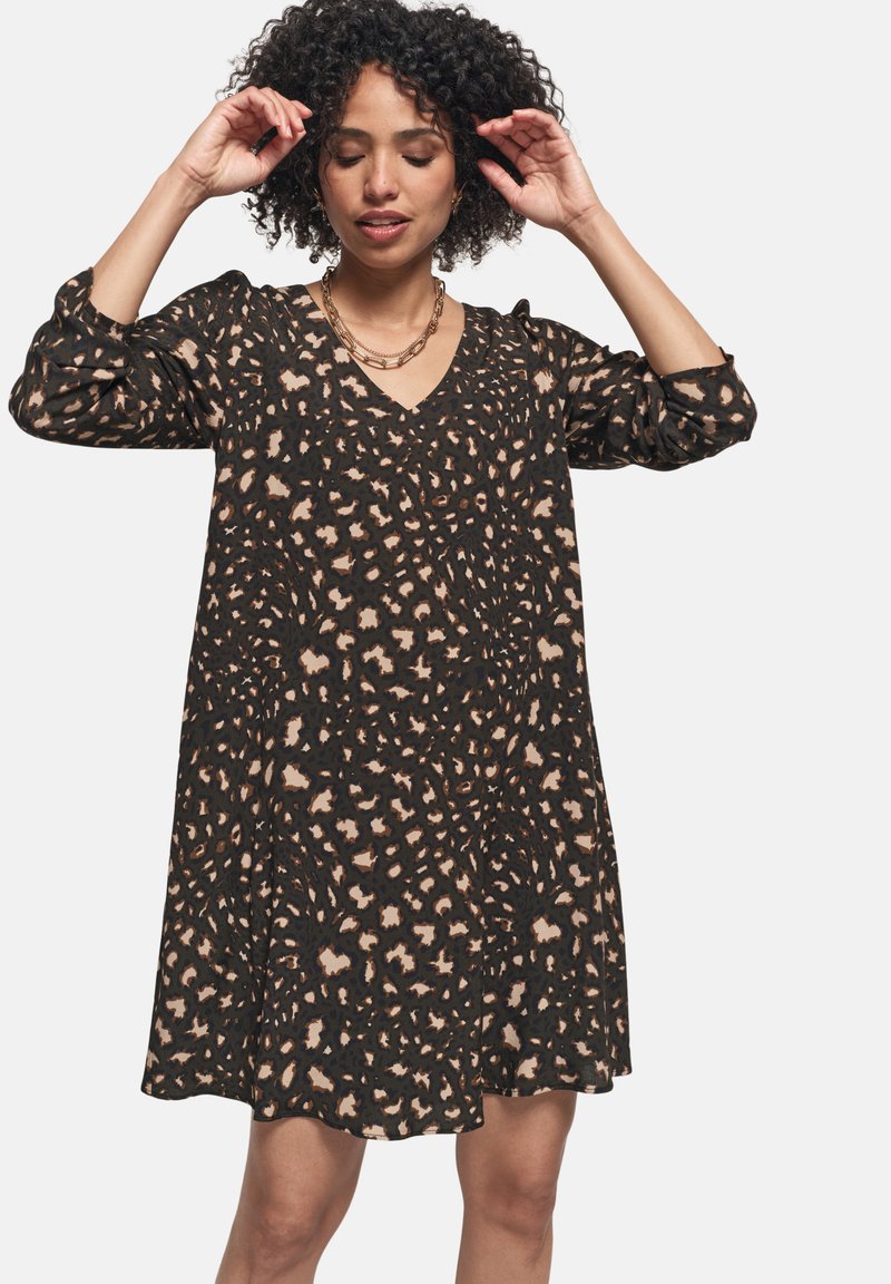 Vestido negro con estampado de leopardo en tonos beige y marrón. Presenta un escote en V, mangas largas y un corte holgado. Textura suave.