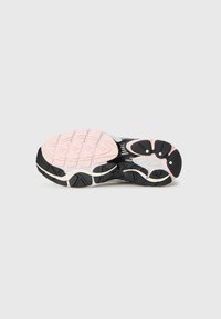 Black and pink athletic shoe sole featuring a textured surface, several traction patterns, and a curved shape for stability.