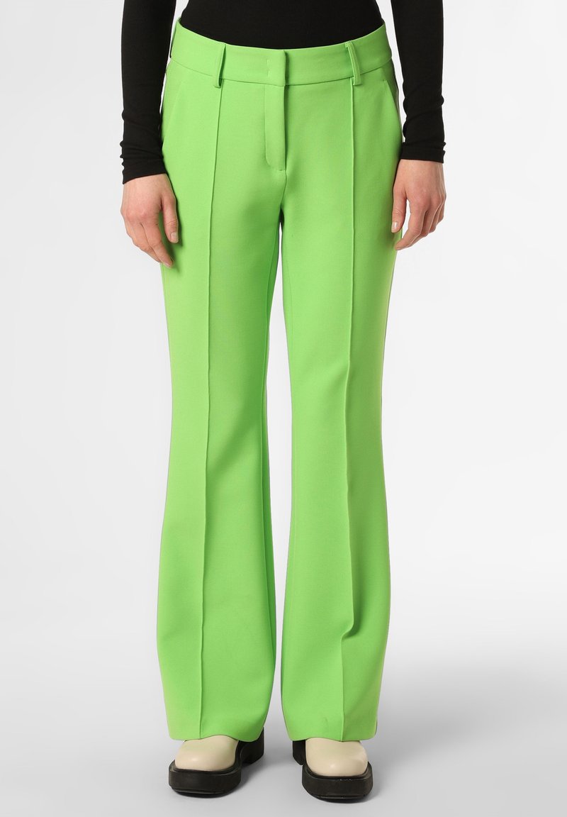 Zelené rozšířené kalhoty vyrobené z hladkého materiálu, s vysokým pasem, sklady a přiléhavým střihem, spárované s robustními černými botami.