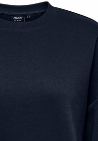 Felpa blu navy realizzata in tessuto morbido, con collo a giro, maniche lunghe e dettagli di cucitura minimali sulle spalle. Taglia S.